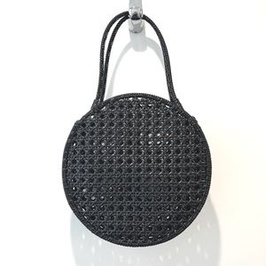 Black round woven bag made of plastic straw
